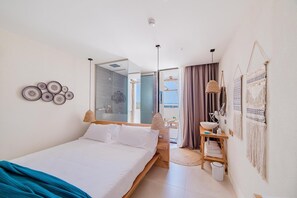 A modern bedroom with a bed, a vanity, and a bathroom visible through an open door. - Cumeja Beach Club Hotel (Cellole)