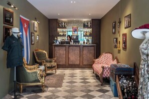 A bar area with a bartender, vintage chairs, and a flag on the wall. - Quba by Montraj Pattaya (Pattaya)