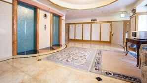 A hotel lobby with a marble floor, a large chandelier, and a reception desk. - Hotel San Marco (Daito)