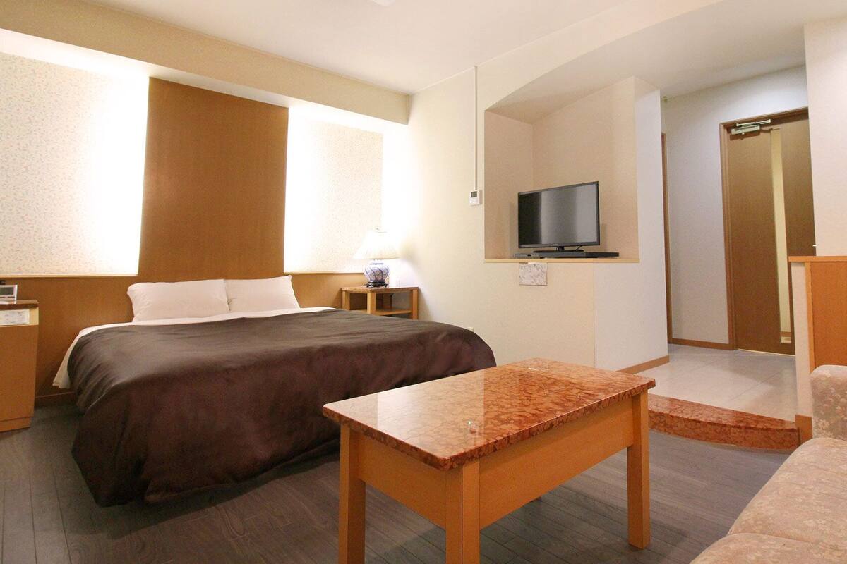 Une chambre d’hôtel équipée d’un lit, d  ’une télévision, d’un bureau et d’une armoire.