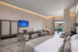 Una habitación de hotel moderna con cama, zona de estar y televisor.