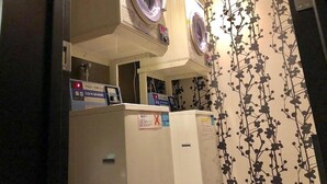 A laundry room with two washing machines, a dryer, and a control panel. - APA Hotel Nanbaminami Ebisucho-eki (Osaka)
