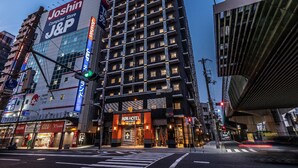 A multi-story building with a prominent J.P. Morgan sign, a J.Crew store, and an APA Hotel entrance. - APA Hotel Nanbaminami Ebisucho-eki (Osaka)