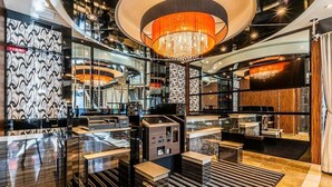 A modern hotel lobby with a central chandelier, a reception desk, and a seating area with a striped rug. - APA Hotel Nanbaminami Ebisucho-eki (Osaka)