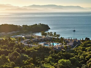 Un complexe hôtelier comprenant plusieurs bâtiments, une piscine et offrant une vue sur la mer.