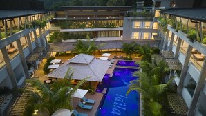 A multi-story hotel with a rooftop pool area, outdoor seating, and lush greenery. - Laila, Seychelles, a Tribute Portfolio Resort (Mahé Island)