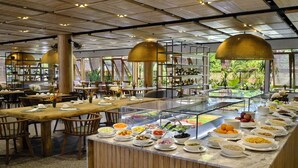 A buffet area with a variety of food options, wooden tables, and chairs. - Laila, Seychelles, a Tribute Portfolio Resort (Mahé Island)