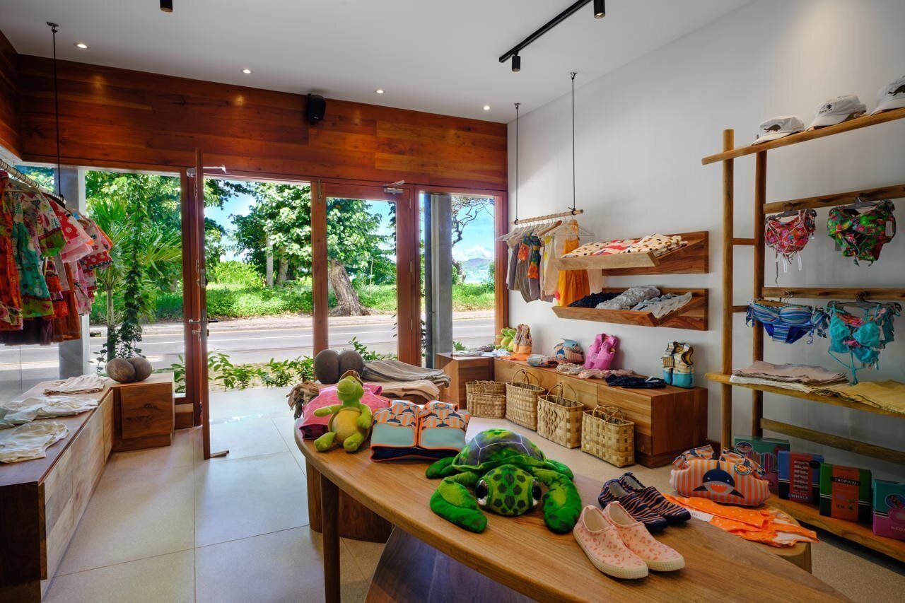 A modern boutique with wooden shelves displaying colorful clothing and accessories.