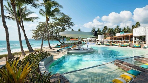 A resort pool area with lounge chairs, a hot tub, and a view of the ocean. - Avani Chaweng Samui Hotel and Beach Club (Koh Samui)