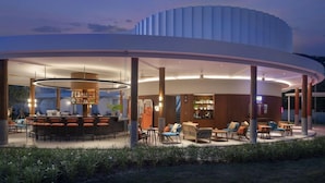A modern building with a circular structure, a bar area, and outdoor seating. - Avani Chaweng Samui Hotel and Beach Club (Koh Samui)