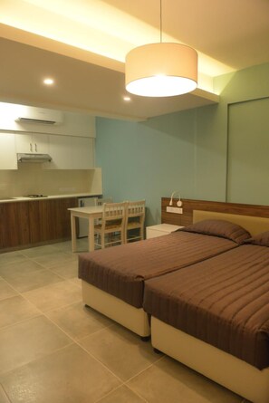 Quarto com cama, mesa de cabeceira e pequena escrivaninha com cadeira.