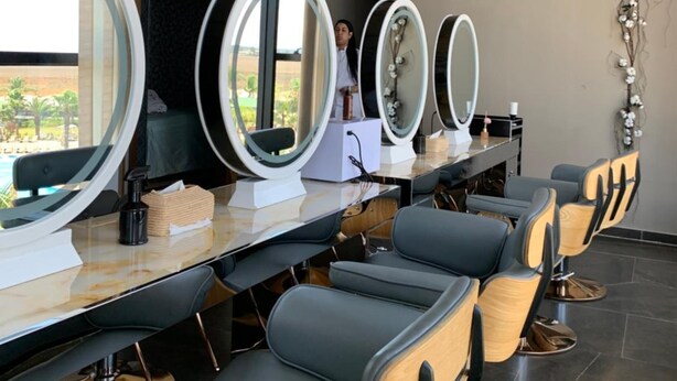 Un salone con diversi specchi, una reception e un cartello che indica che si tratta di Waves Beauty & Medical Spa.