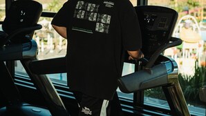 Un uomo corre su un tapis roulant all'interno di una palestra con ampie finestre.
