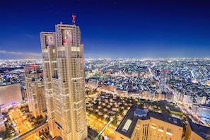 A high-rise building with a distinctive architectural design, surrounded by a cityscape at night. - Hotel Urban (Tokyo)