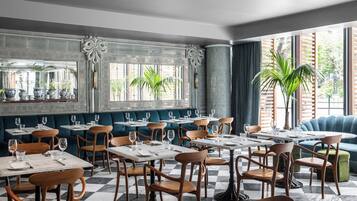 A restaurant interior with checkered flooring, wooden chairs, and tables set for dining.