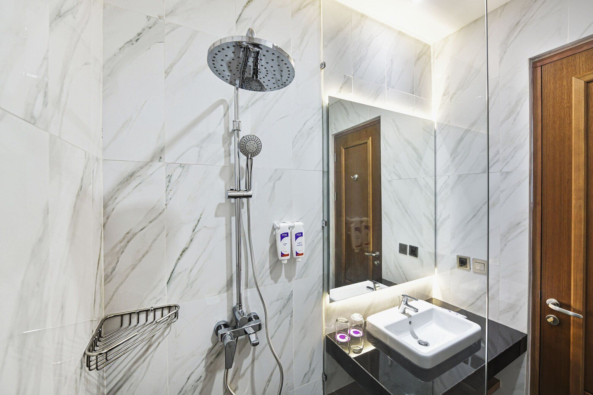 Une salle de bain moderne avec une douche, un lavabo et un miroir.
