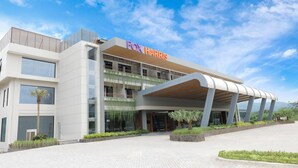 A modern hotel with a prominent 'FOX HARRIS' sign, a covered entrance, and a landscaped entrance area. - FOX Harris Hotel and Convention Banjarnegara (Banjarnegara)