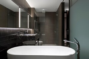 A modern bathroom with a freestanding bathtub, a glass shower enclosure, and a large mirror. - Crowne Plaza Danang City Centre by IHG (Da Nang)