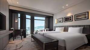 A hotel room with a large bed, a desk, a bench, and a TV. There are three framed pictures on the wall. - Crowne Plaza Danang City Centre by IHG (Da Nang)