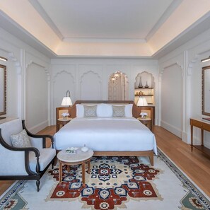 A spacious bedroom with a large bed, two bedside tables with lamps, a small round table, a sofa, and a patterned rug. - The Chedi Katara Hotel and Resort - a GHM Hotel (Doha)