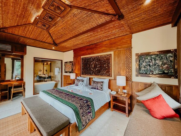 A spacious bedroom with a large bed, a wooden ceiling, and a view of the bathroom. - Sakti Garden Resort and Spa (Ubud)