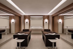 A modern spa room with two massage tables, a central sink, and mirrored walls. - Xanadu Makadi Bay (Makadi Bay)