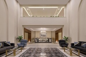A spacious lobby with a reception desk, two sofas, and a patterned floor. - Xanadu Makadi Bay (Makadi Bay)