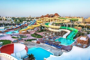 A water park with multiple slides and pools, surrounded by umbrellas and lounge chairs. - Xanadu Makadi Bay (Makadi Bay)