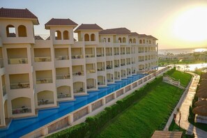 A hotel with multiple balconies, a swimming pool, and a view of the sea. - Xanadu Makadi Bay (Makadi Bay)