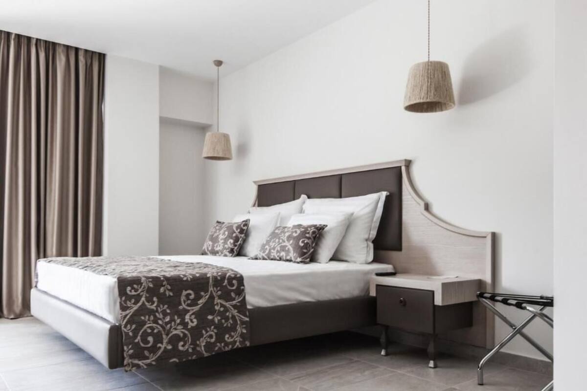 Een moderne slaapkamer met een bed, nachtkastje en hanglamp.