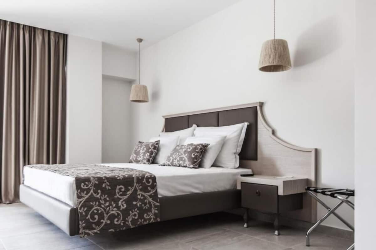 A modern bedroom with a bed, bedside table, and a hanging light fixture.