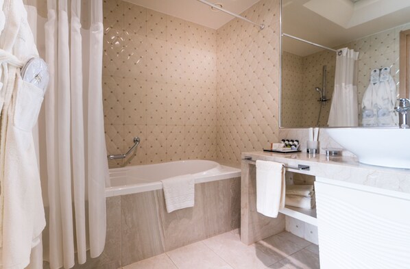 A bathroom with a bathtub, shower, and a large mirror. - Elinotel Sermilia (Polygyros)