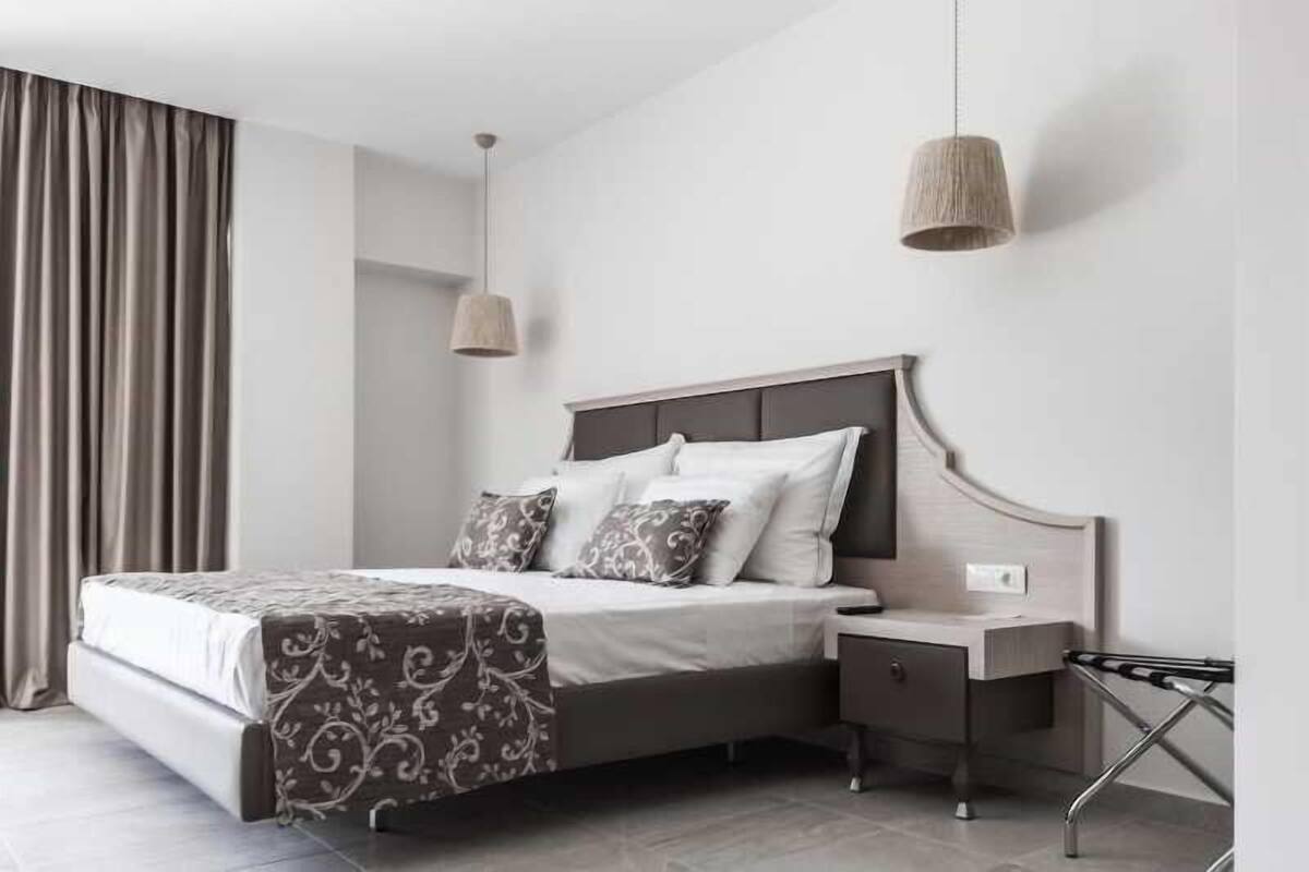 Een moderne slaapkamer met een bed, nachtkastjes en een hanglamp.