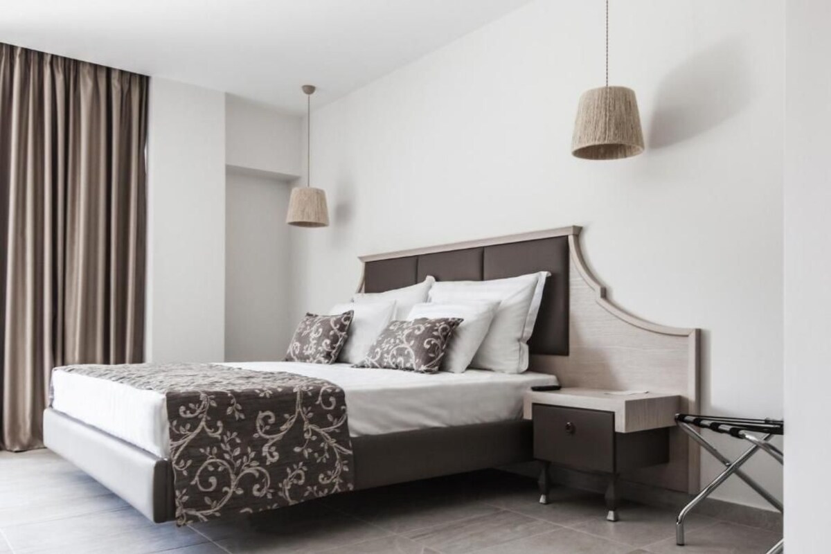 A modern bedroom with a bed, bedside table, and a hanging light fixture.