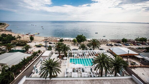 Een resort met zwembad, strand en uitzicht op de oceaan.