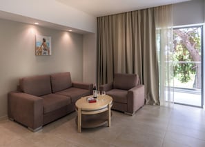 A modern living room with a brown sofa, a smaller armchair, and a round coffee table.