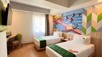 Una habitación de hotel con dos camas, un escritorio, una silla y un mural grande en la pared.