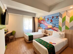Una habitación de hotel con dos camas, un escritorio, una silla y un mural grande en la pared.