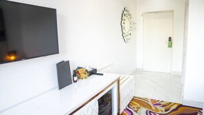 A modern hotel room with a flat-screen TV, a small table with snacks, a remote control, and a patterned rug. - A Hotels (Brondby)