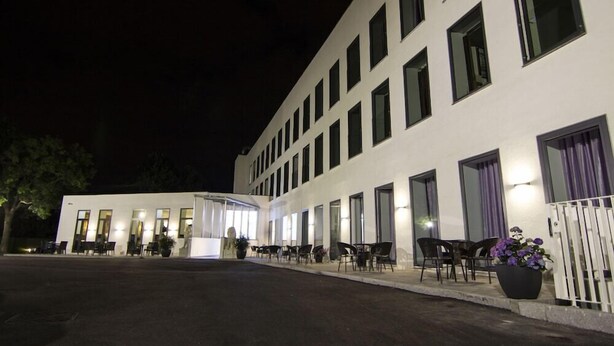 A modern building with multiple windows and a covered outdoor seating area. - A Hotels (Brondby)