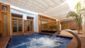 A spa area with a hot tub, wooden deck, and a covered entrance. - Fort Arabesque The Villas (Makadi Bay)