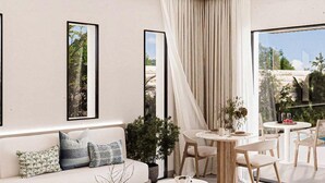 A modern living room with a sofa, coffee table, and dining area. - Fort Arabesque The Villas (Makadi Bay)