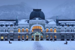 A grand building with a large central dome and arched windows, surrounded by snow. - Canfranc Estación, a Royal Hideaway Hotel (Canfranc)