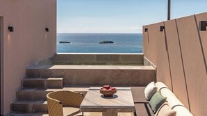 A balcony with a view of the sea, a hot tub, and a seating area with cushions. - Tetra Resort and Spa (Kefalonia)