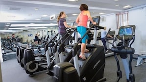 Ein Fitnessstudio mit Laufbändern, Spiegeln und einer verspiegelten Wand.
