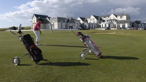 Un terrain de golf avec un club-house en arrière-plan.