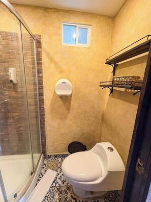 A bathroom with a shower, toilet, and a small window. - Hotel Rancho Argueta (San Luis Talpa)