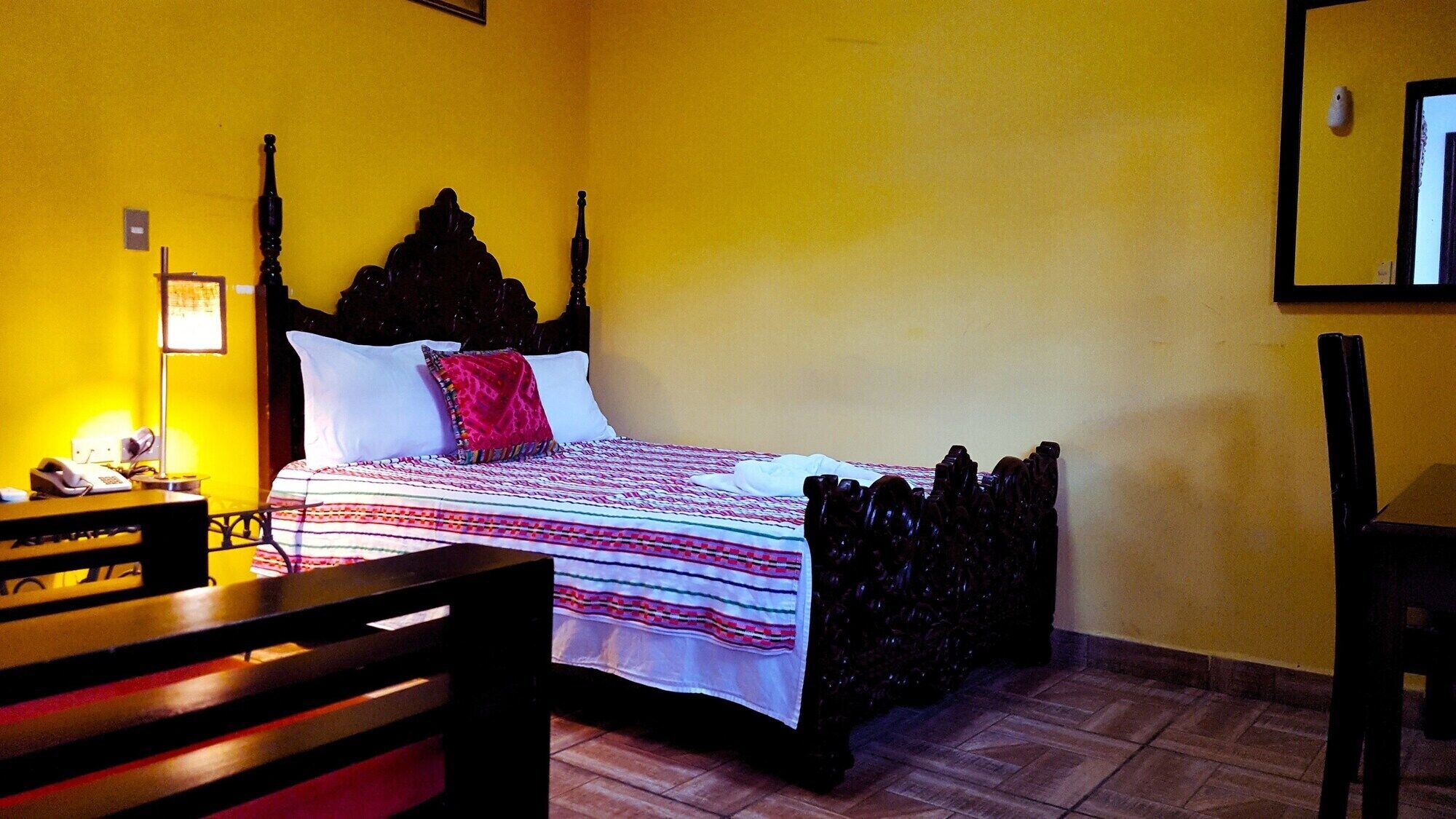 A room with a bed, a desk, and a chair.
