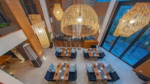 A spacious lobby with high ceilings, modern furniture, and large, woven pendant lights. - Hotel Otavalo (Otavalo)