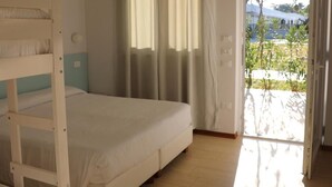 A bedroom with a bunk bed, a single bed, a window with curtains, and a door leading outside. - Futura Club Acqua Di Venere (Capaccio-Paestum)